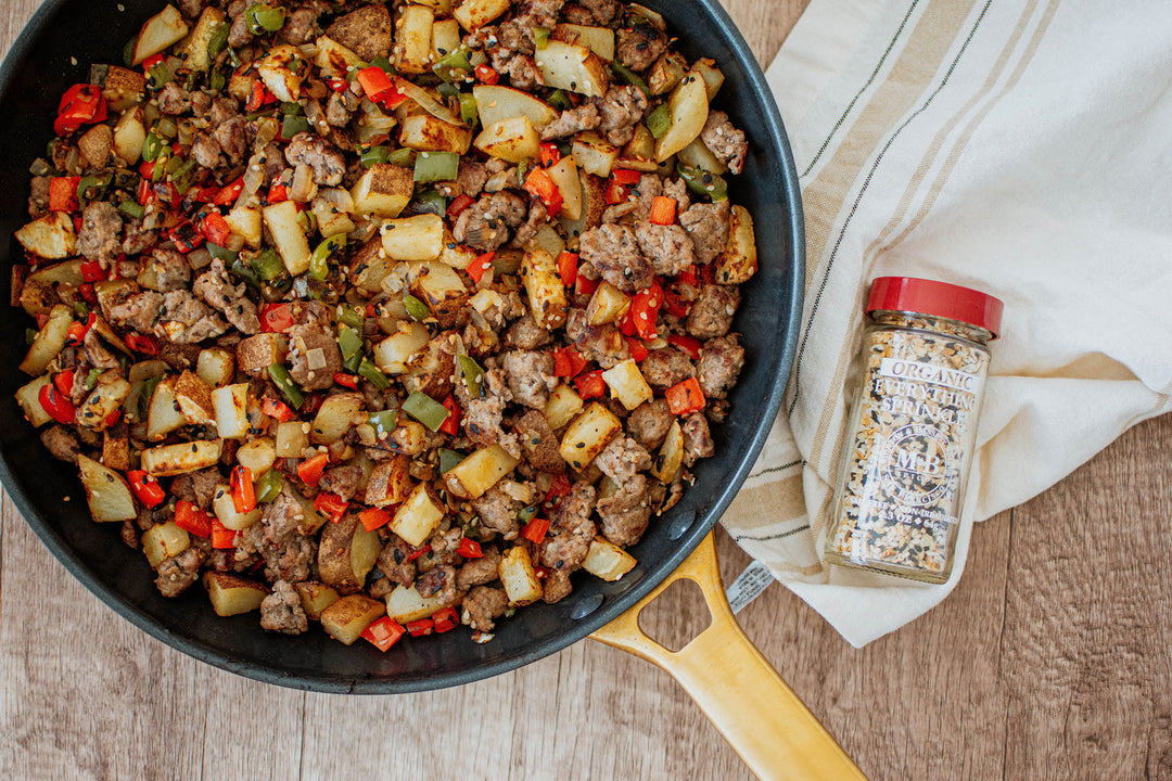 breakfast hash with potatoes, peppers, onion, sausage, and a sunny side up egg