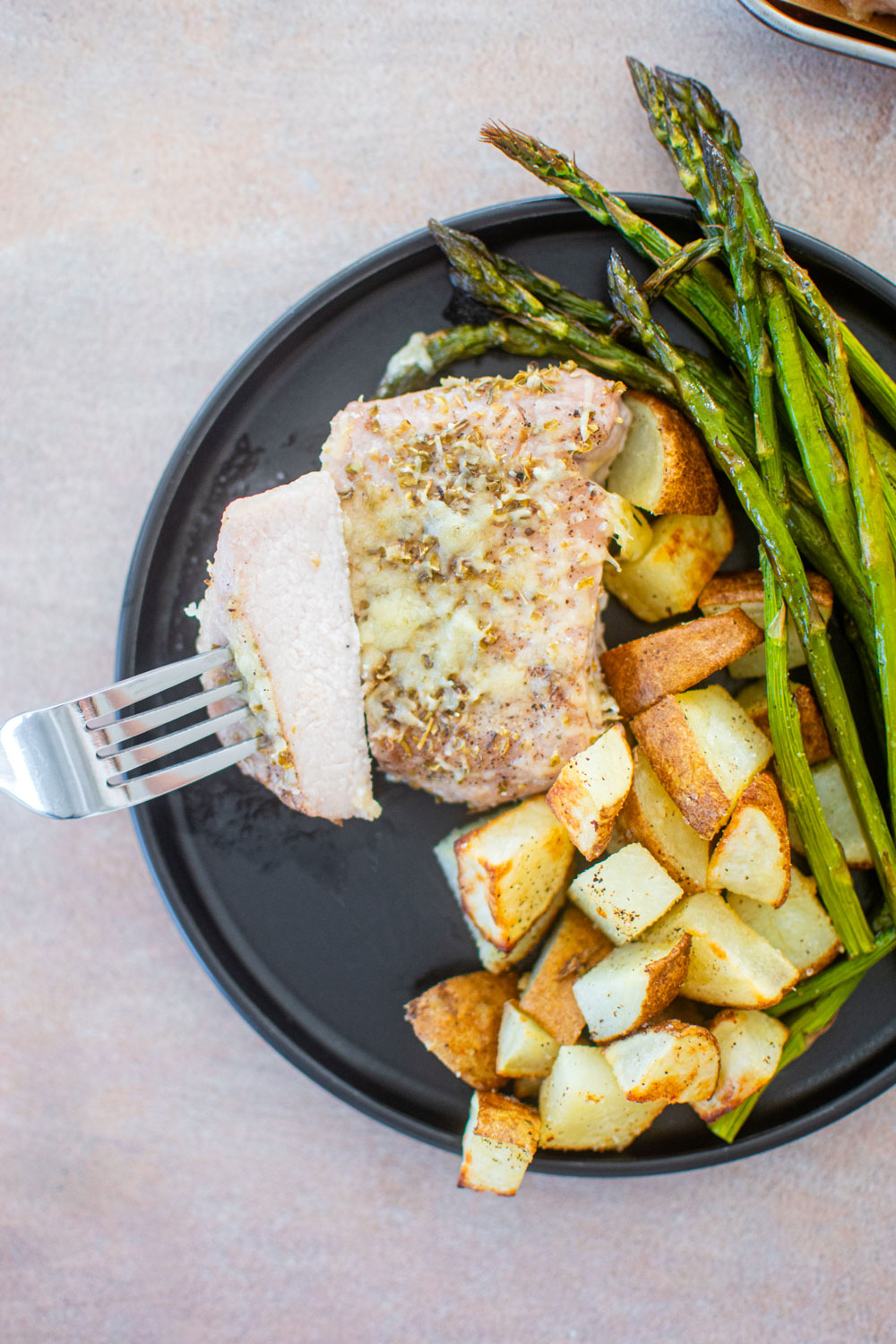 pork chop on plate with potatoes and apsaragus